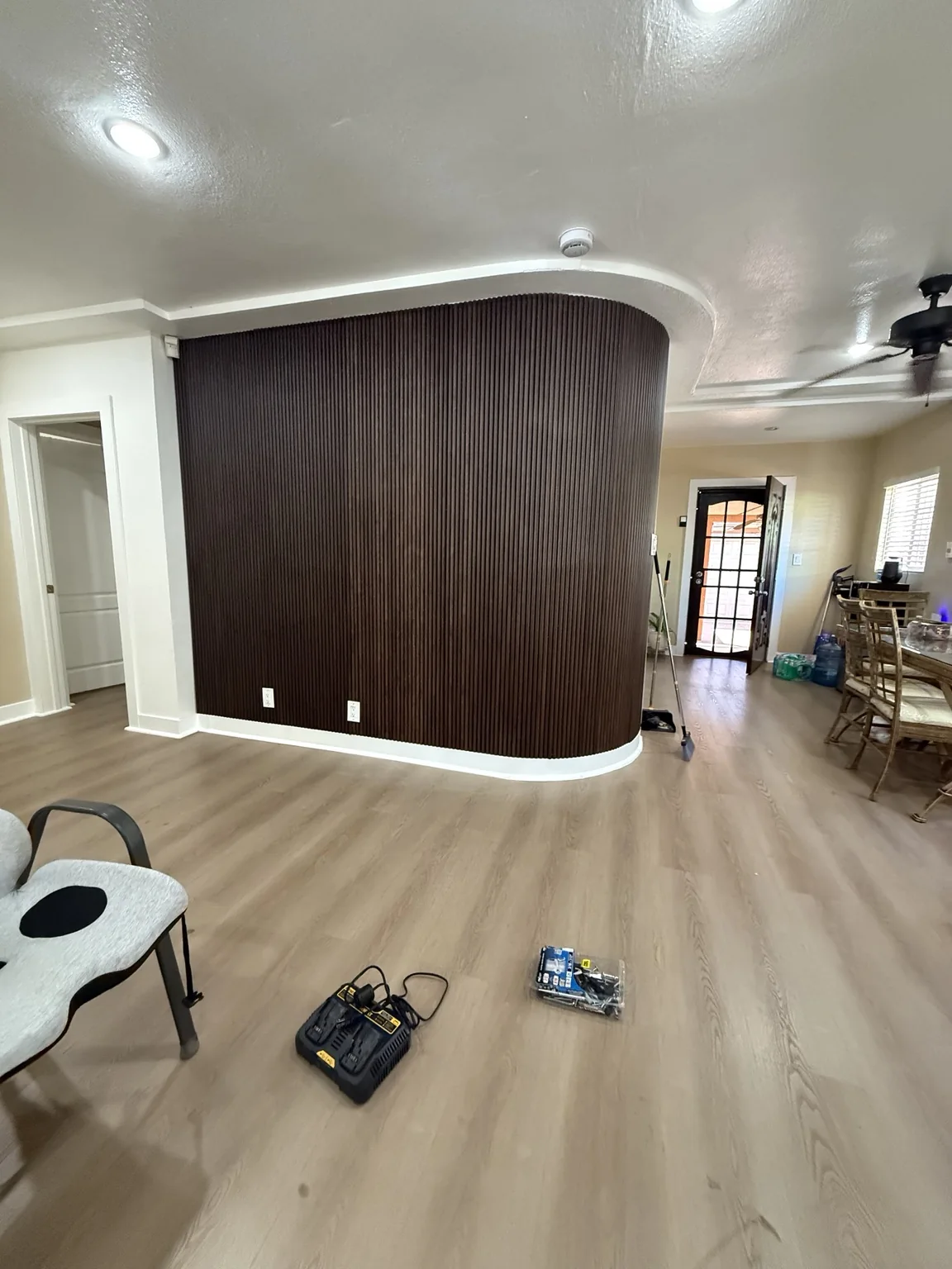 Dark wood slat accent wall installed along a curved feature wall