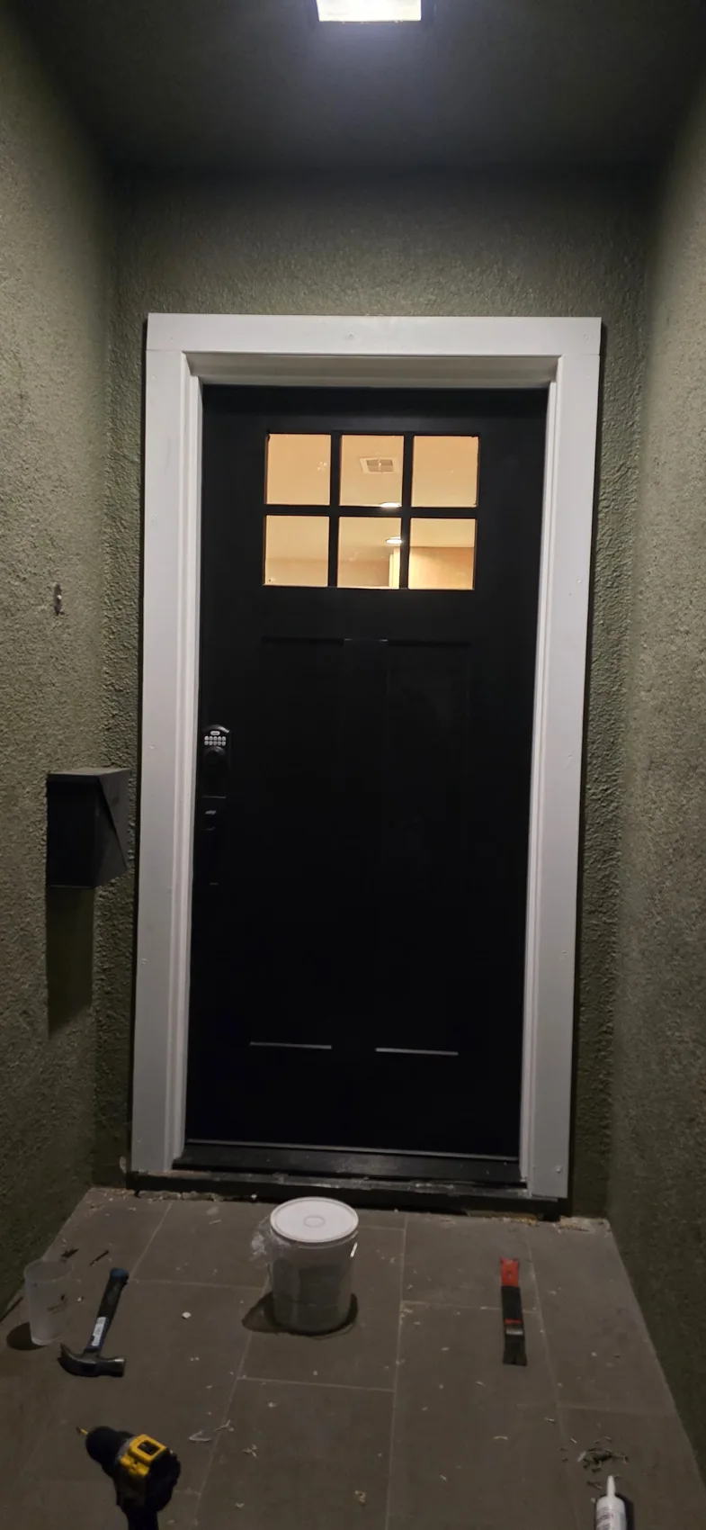 Black six-pane entry door and white trim