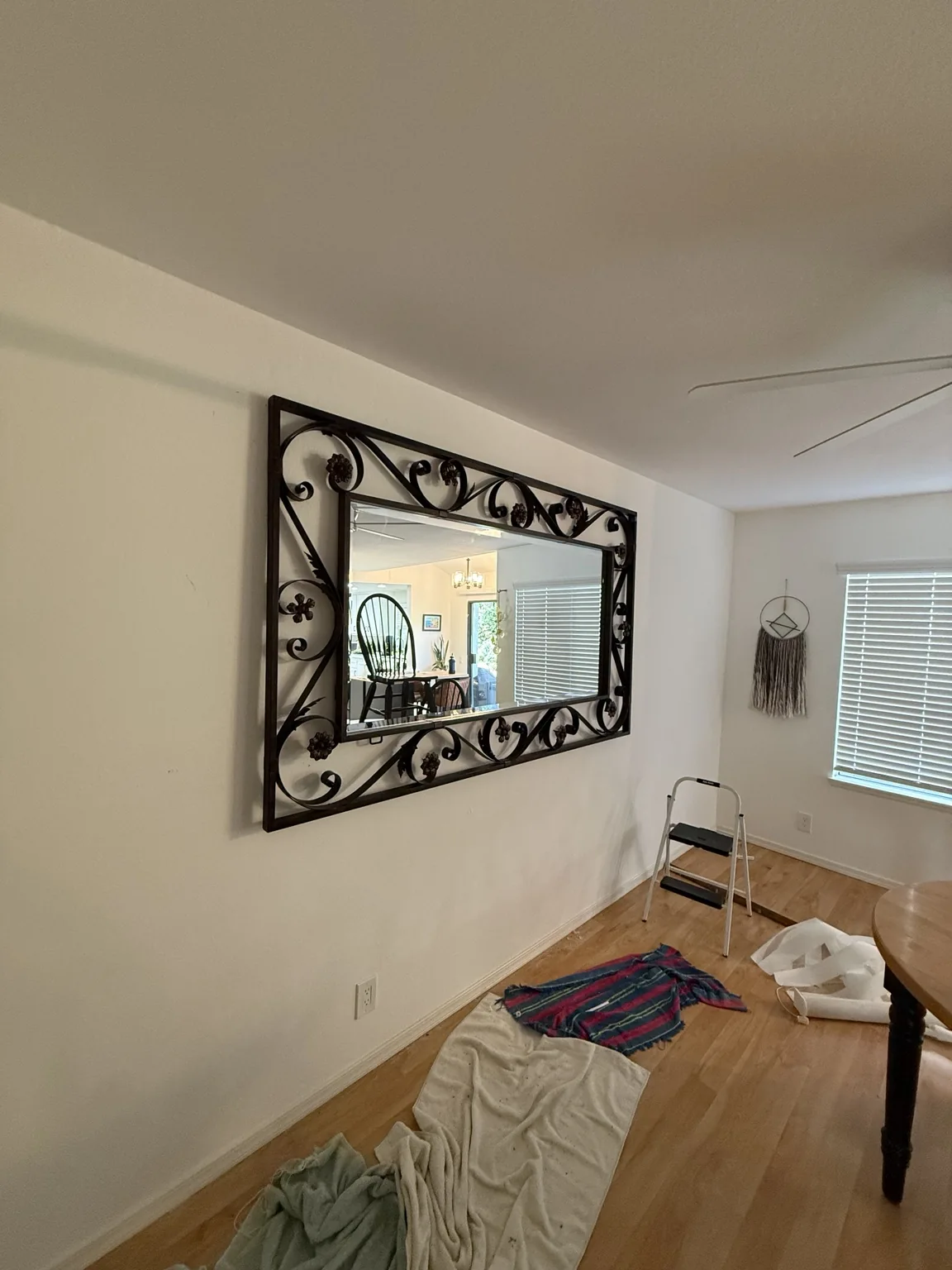 Large decorative wrought iron framed mirror mounted on a wall