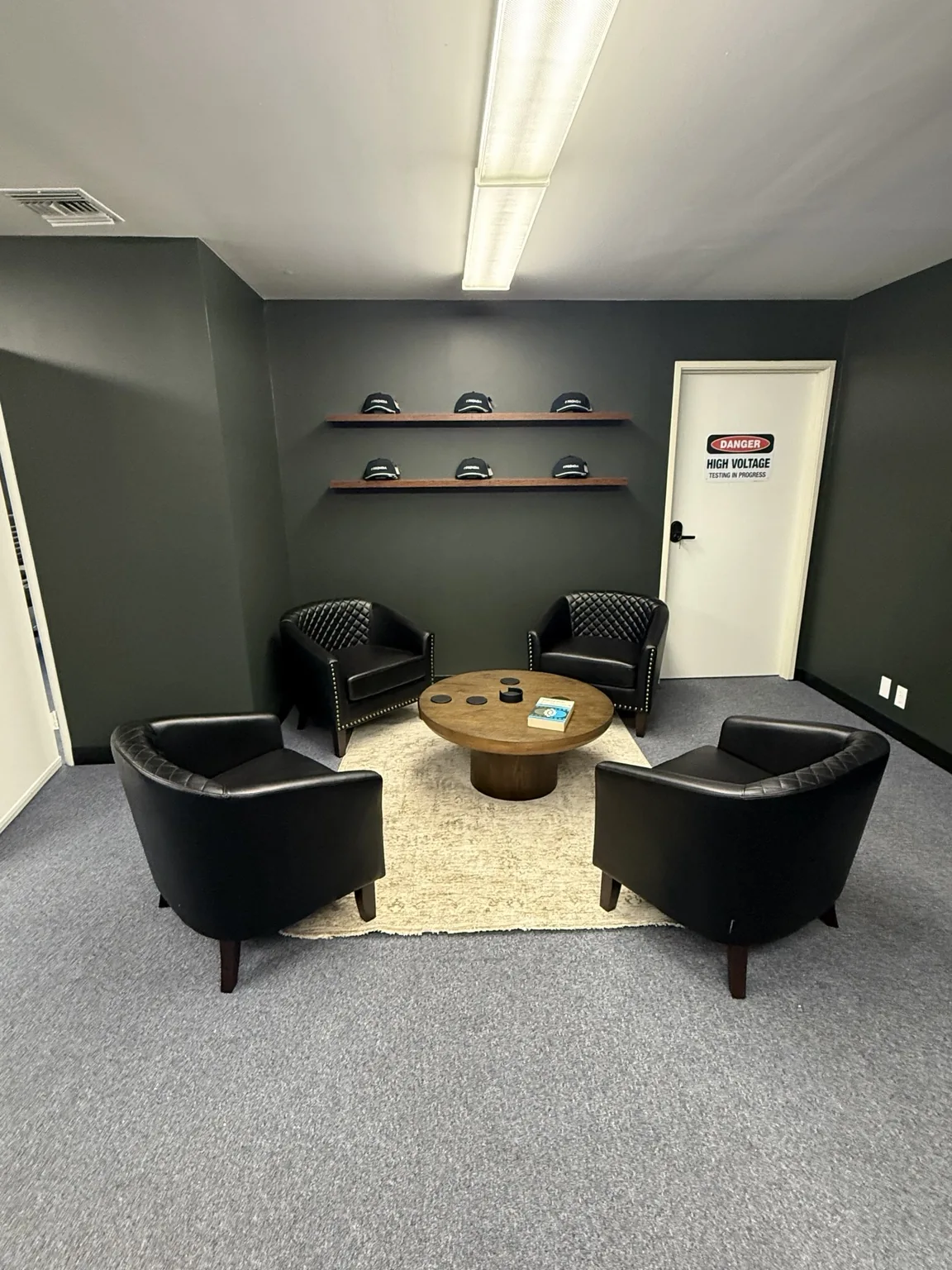 Office seating area with chairs, a round table and floating shelves